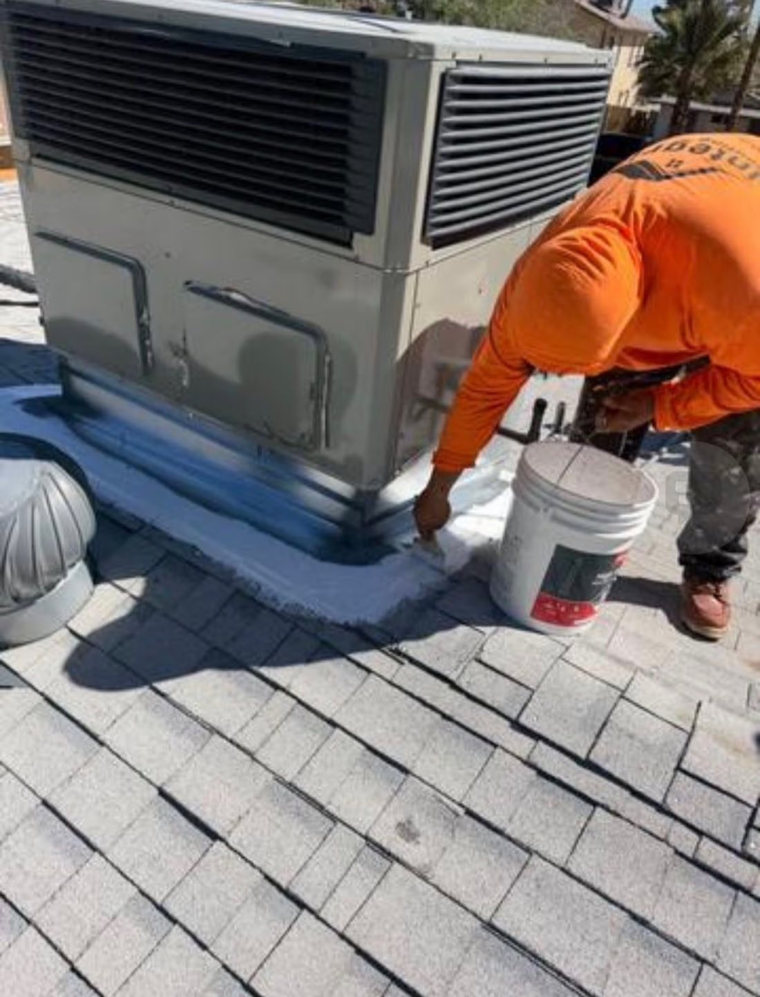 Integrity Roofing crew member sealing around a rooftop unit on a Las Vegas home